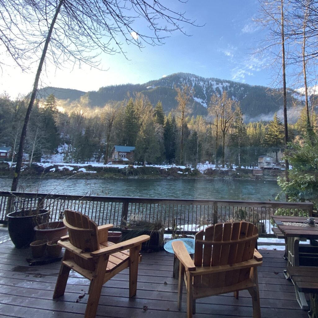 A cabin deck with two chairs and a view of the mountains in Index, Washington.