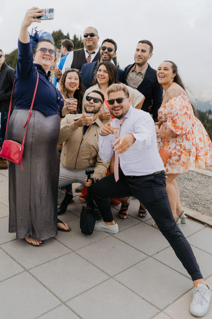 A group of wedding guests takes a selfie atop Crystal Mountain. 