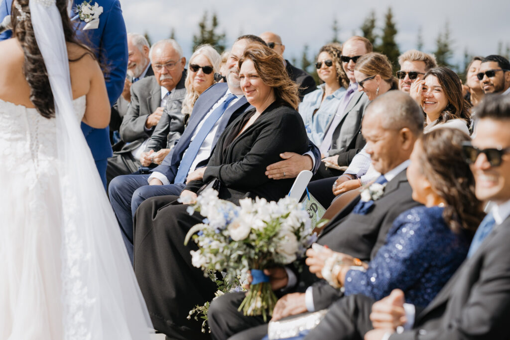 The wedding guests look out at the bride and groom while exchanging wedding vows at Crystal Mountains Mt. Rainier Platform. 