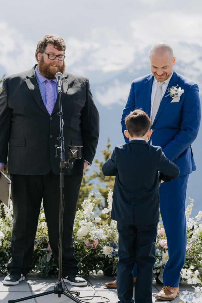 The ring bearer presenting the rings to the groom on his wedding day near Mt. Rainier National Park.