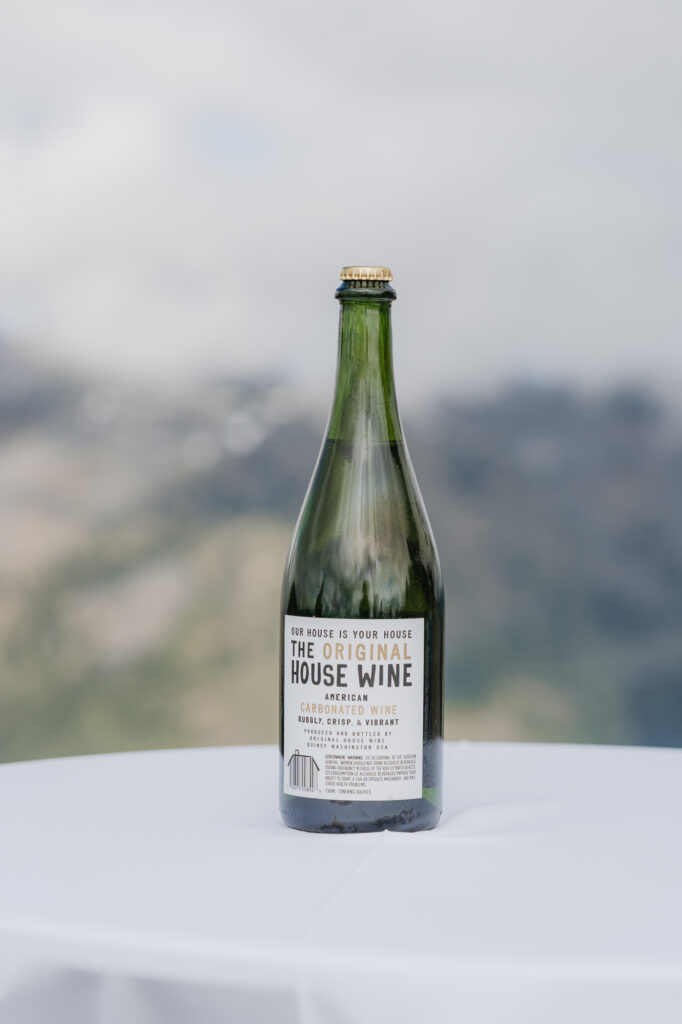 A wine bottle waiting to be served with a view of Mt. Rainier. National park in the background. 