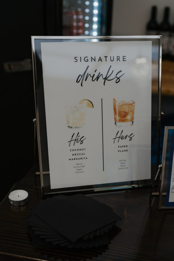 A sign of his and her signature drinks at the reception of a Crystal Mountain wedding. 
