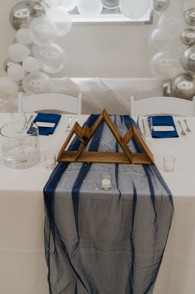 A wedding day table decorated with blue accents and candles.