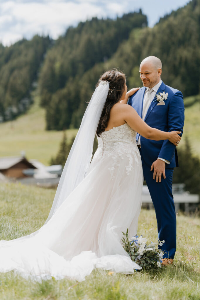 A bride embraces the groom on their wedding day while standing at the base of Crystal Mountain. 