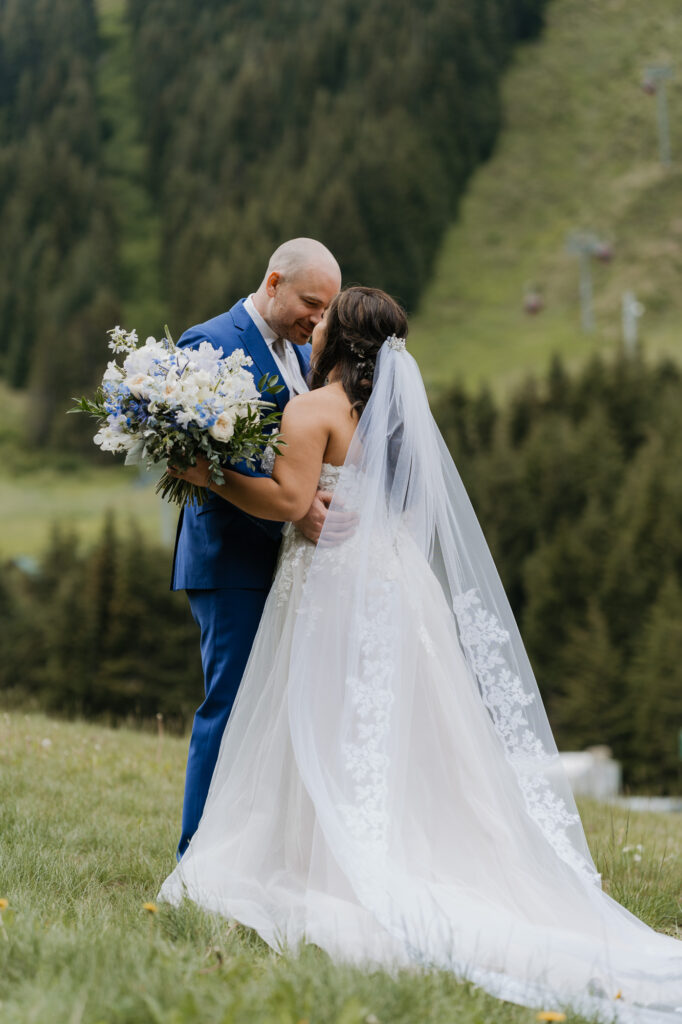 A bride and groom embrace each other at the base of Crystal Mountain on their wedding day.