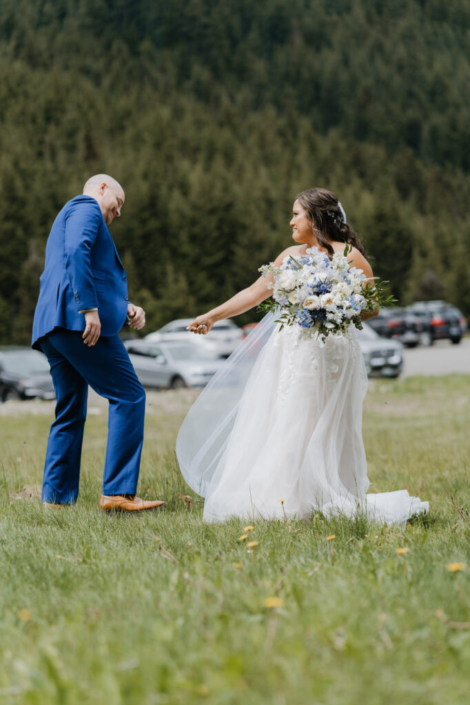 A groom checks out the bride's wedding dress right after their first look on their wedding day at Crystal Mountain Resort, near Mt. Rainier National Park. 