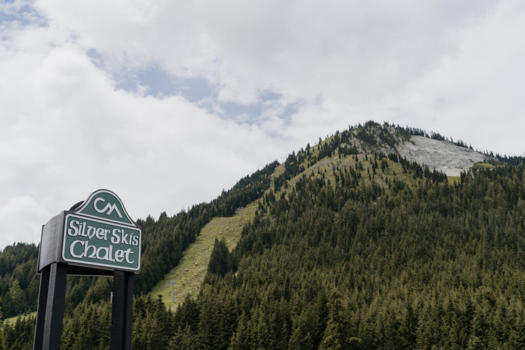 The sign for the Silver Skis Chalet Condominiums at Crystal Mountain resort with the mountain in the background.