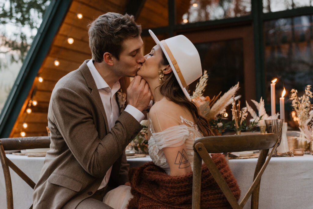 A bride and groom kissing in front of a cabin in Washington on their elopement day.