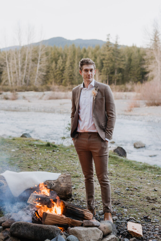 A groom standing in front of a bonfire