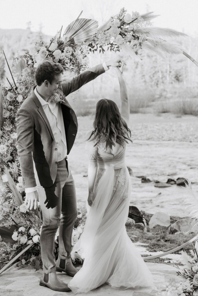A couple twirling on their elopement day along the river in Packwood, WA
