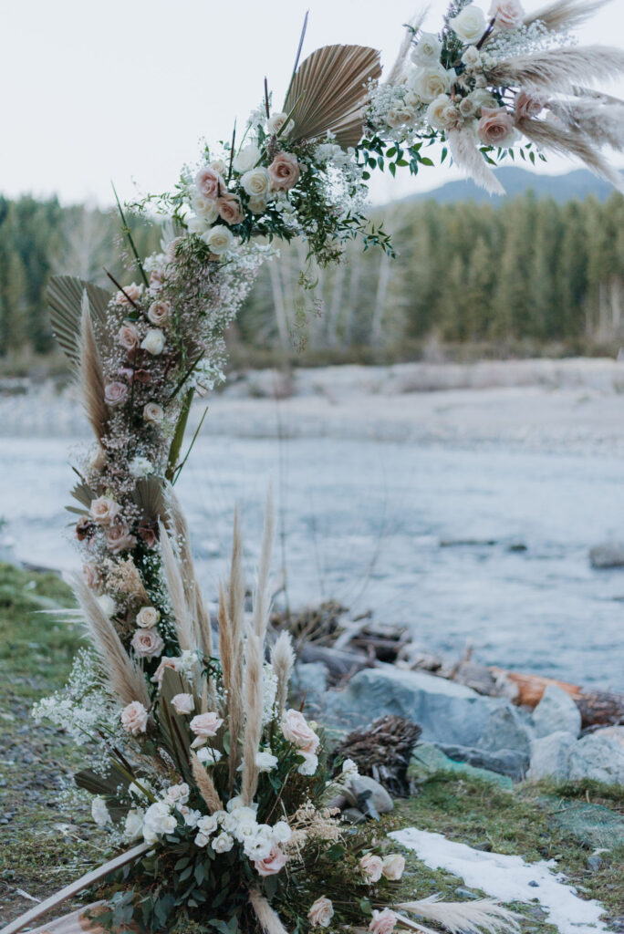 Washington elopement featuring a flower arch along the river at blue hour.