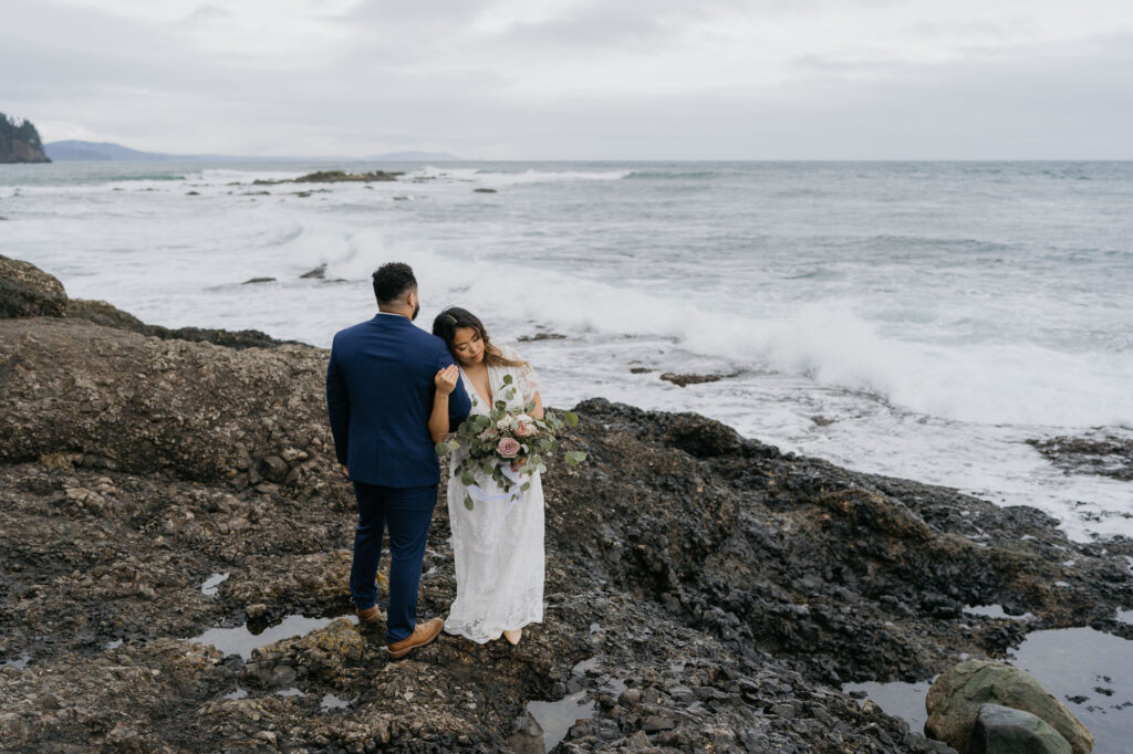An elopement on the Washington Coast. the couple is standing on a rocky shore near Port Angeles Washington.